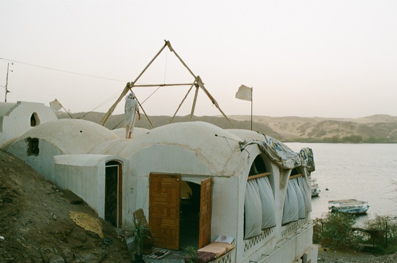 Tekkeya's white domed house on the hill above the Nile, a wooden pyramid frame on its roof