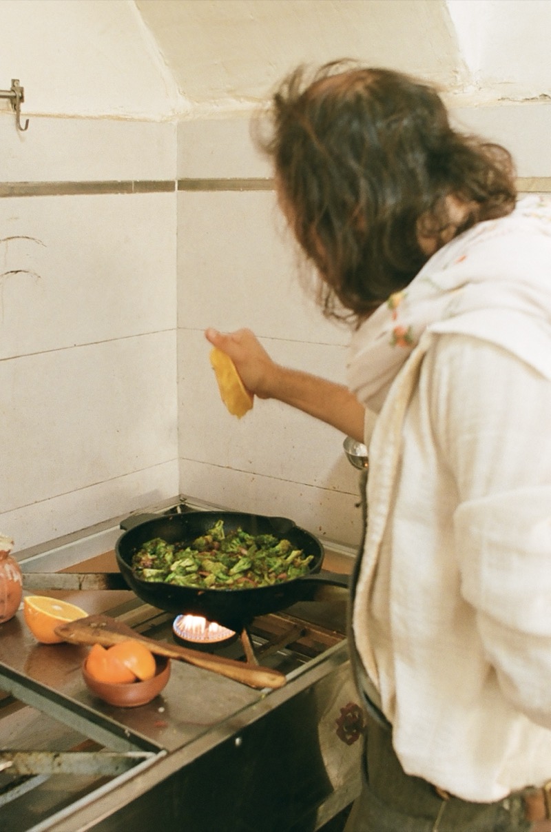 George cooking greens in a cast-iron pan