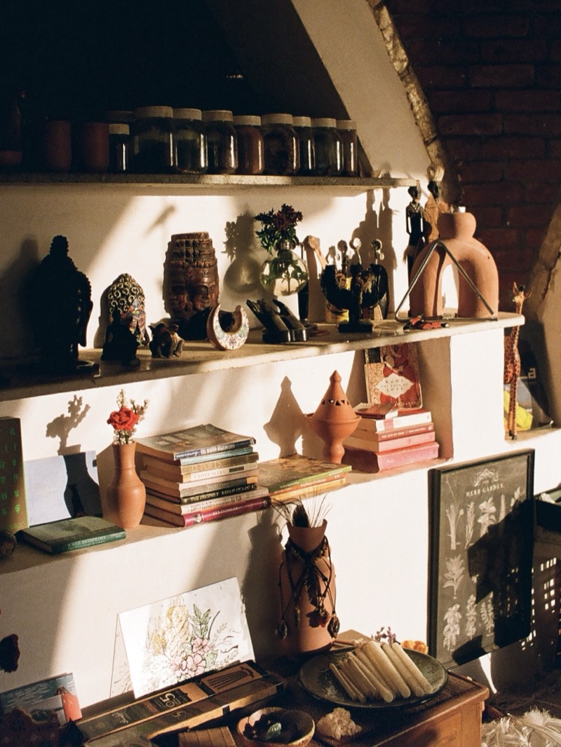 Sunlit shelves of books, clay pots and small treasures